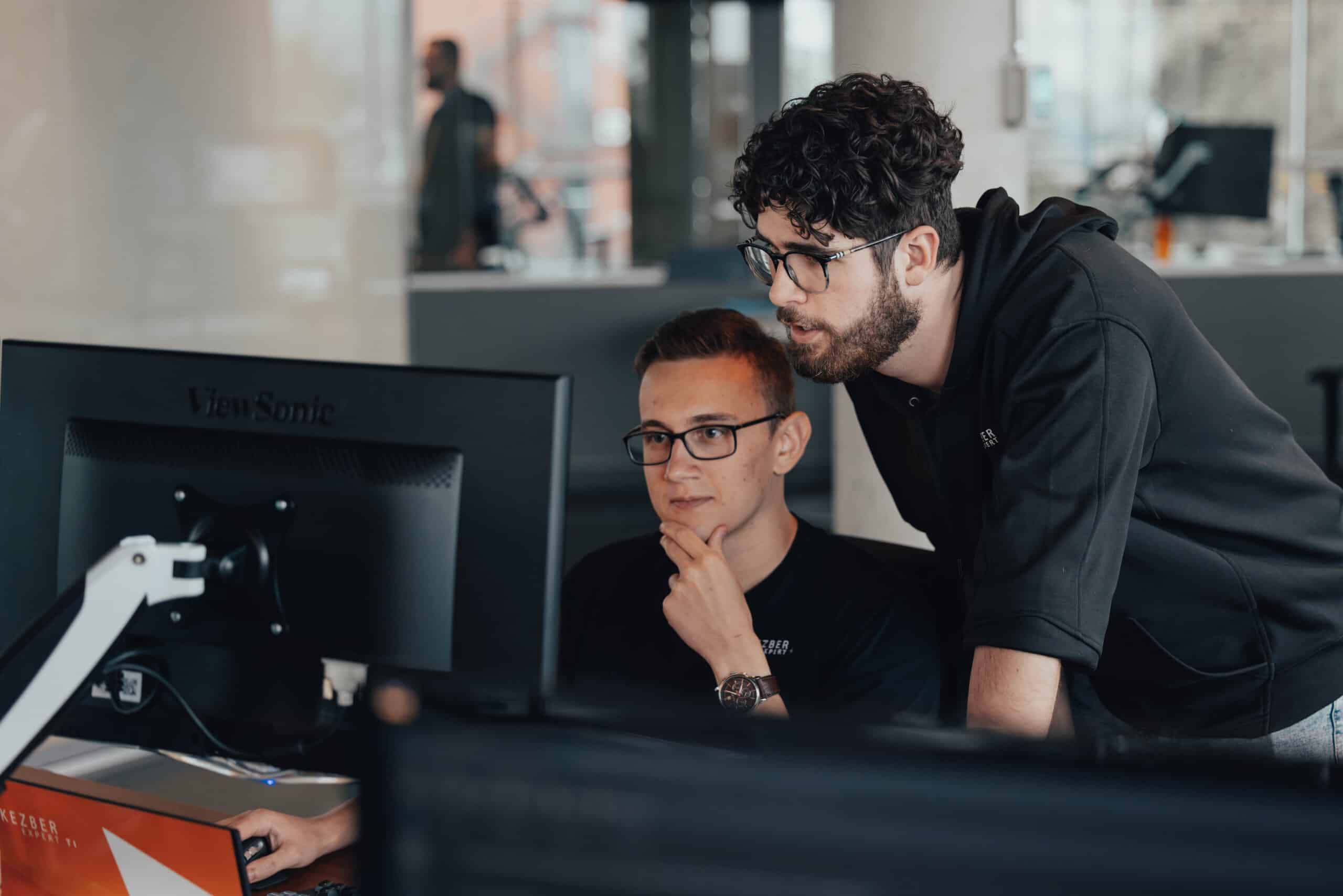 2 hommes regardent écrans